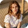 Reference thumbnail of a woman by a chain-link fence in warm evening light